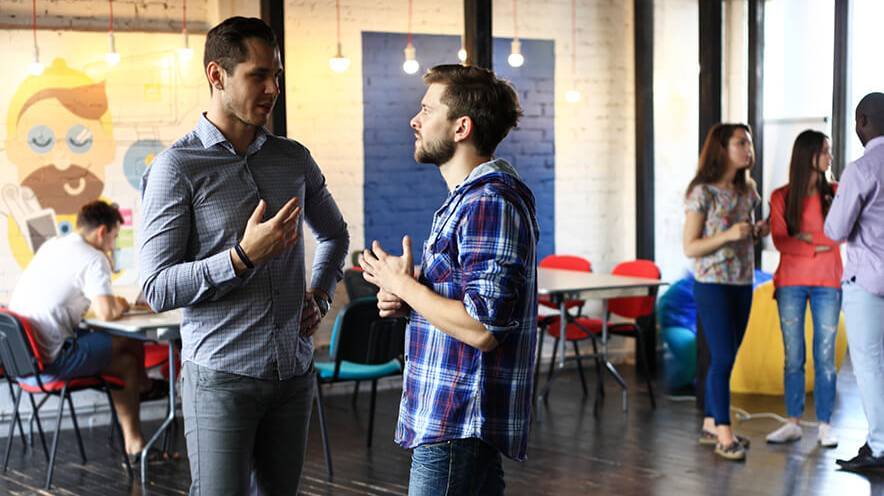 Deux étudiants discutants dans un espace de co-working